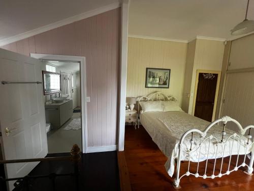 a bedroom with a bed and a bathroom with a sink at Homestead BnB in Maudsland