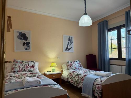 una camera da letto con due letti e una finestra di Casa Rural La Gospa a Urda