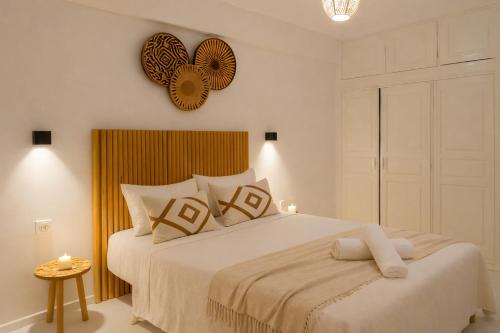 a bedroom with a large white bed and a clock on the wall at 2BR Luxury Apartment-Heart Of Taghazout, Private Beach Access, Panoramic View, Remote Work 100Mbps, Walk to Restaurants in Taghazout