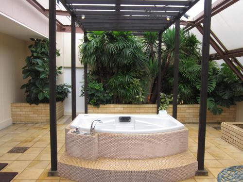 a hot tub in a room with plants at Hotel Aura Daito (Adult Only) in Daitō