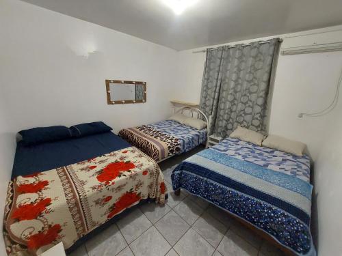 a bedroom with two beds in a room with a window at POUSADA TEMPORADA BIBi casa inteira com café in São Gabriel