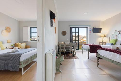 a bedroom with two beds and a dining room at MyRiverPlace N 4 Private Terrace River View Porto apartments in Vila Nova de Gaia