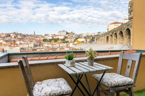 a table and chairs on a balcony overlooking a city at MyRiverPlace N 4 Private Terrace River View Porto apartments in Vila Nova de Gaia