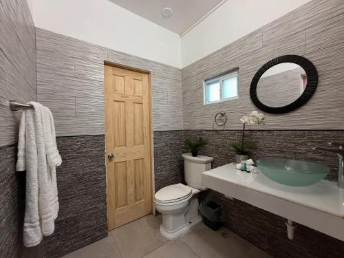 a bathroom with a sink and a toilet and a mirror at BethsAida Conference Center & Boutique Accommodations in Simpson Bay