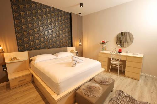 a bedroom with a bed and a desk and a chair at Linza Cozy Vila in Tirana
