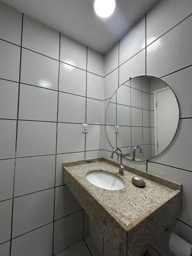 a bathroom with a sink and a mirror at Condomínio Lençóis Flat Resdence in Barreirinhas
