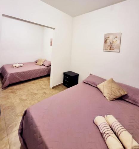 a bedroom with two beds with purple sheets at Colonial Travel Popayán in Popayan