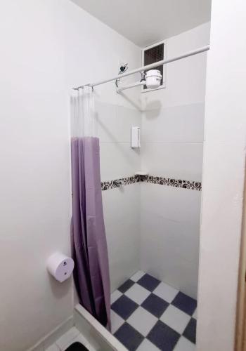 a bathroom with a shower with a purple shower curtain at Colonial Travel Popayán in Popayan
