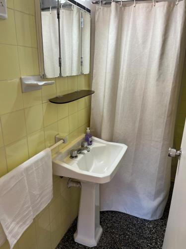 a bathroom with a sink and a shower curtain at Edificio Carbe Punta del Este - Frente al Mar -parada 2 de la Mansa in Punta del Este