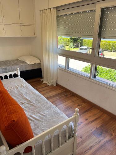 a bedroom with two beds and a large window at Edificio Carbe Punta del Este - Frente al Mar -parada 2 de la Mansa in Punta del Este