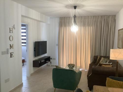 a living room with a couch and a tv at Urban Nest - near GSP & General Hospital in Laxia