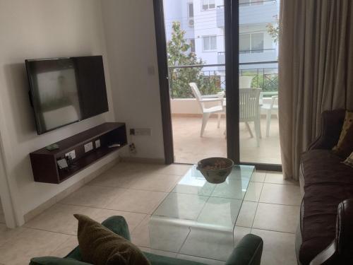 a living room with a tv and a couch at Urban Nest - near GSP & General Hospital in Laxia