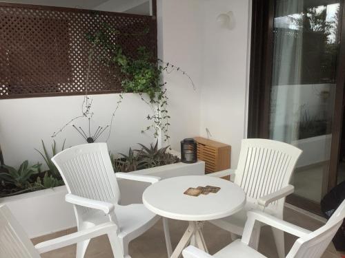 three white chairs and a table and a table and chairs at Urban Nest - near GSP & General Hospital in Laxia