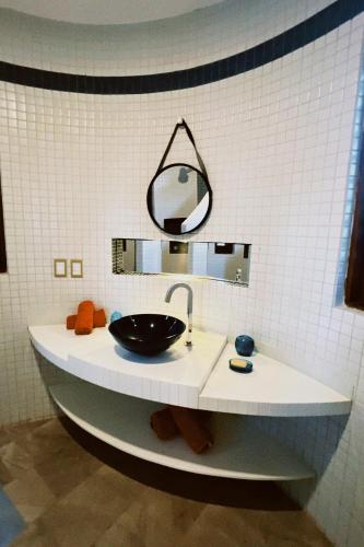 a bathroom with a sink and a mirror on a counter at Casa do Prãna in Guajiru