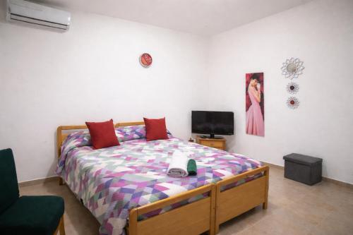 a bedroom with a bed and a flat screen tv at Casa Cera Arras in Dolianova