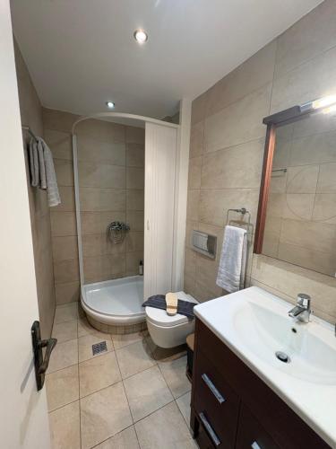 un bagno con vasca, WC e lavandino di Glyfada Menigos Apartment 21 a Glifada (Glyfada)