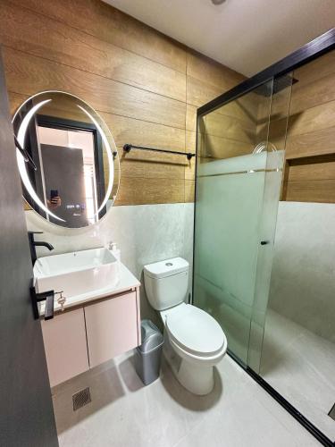 a bathroom with a toilet and a sink and a mirror at Dulce Experiencia Departamento de 2 dormitorios in Santa Cruz de la Sierra
