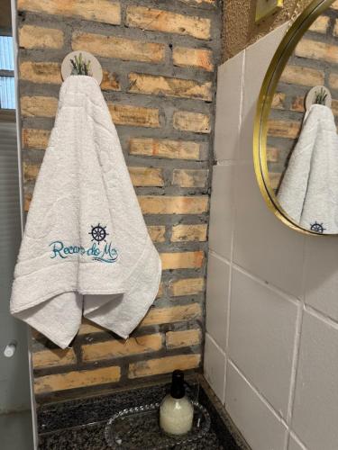 a bathroom with two towels hanging on a brick wall at Recantodomarsaojose in São José de Ribamar
