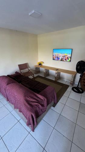 a bedroom with a bed and a flat screen tv at Recantodomarsaojose in São José de Ribamar