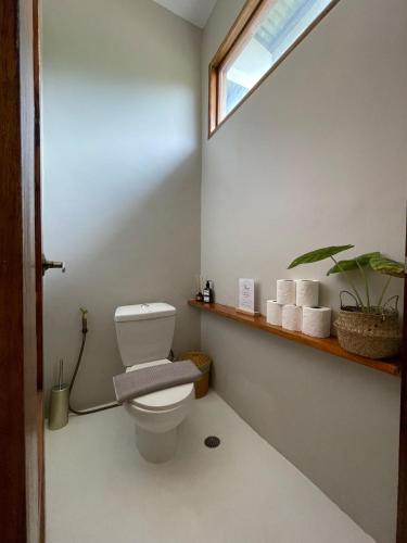 ein Badezimmer mit weißer Toilette und Fenster in der Unterkunft Suenos Villas Siargao in General Luna