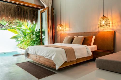 ein Schlafzimmer mit einem Bett und einem großen Fenster in der Unterkunft Suenos Villas Siargao in General Luna