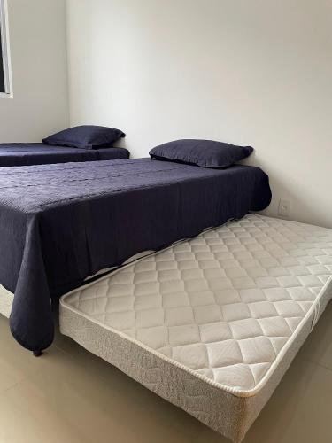 two beds sitting next to each other in a bedroom at CAMINHOS do MAR ACOMODAÇÕES in Parnamirim