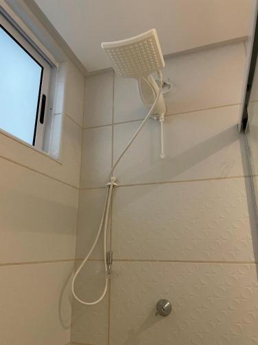 a shower head in a bathroom with a window at CAMINHOS do MAR ACOMODAÇÕES in Parnamirim