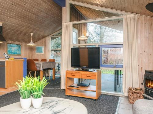 a living room with a television on a table with a fireplace at Luxury Retreat near Kvie So - By Traum Ferienwohnungen in Ansager