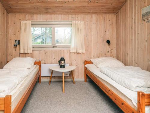 two beds in a room with a table and a window at Luxury Retreat near Kvie So - By Traum Ferienwohnungen in Ansager