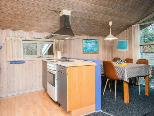a kitchen and dining room with a table and a stove at Luxury Retreat near Kvie So - By Traum Ferienwohnungen in Ansager