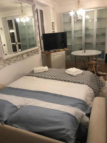 two beds in a room with a table and a tv at Casa Lago Como in Perledo