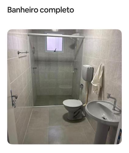 a bathroom with a shower and a toilet and a sink at Pousada da Praça in Rosário do Sul