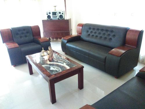 a living room with two couches and a coffee table at Illumination Stay in Negombo