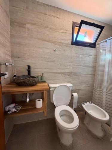a bathroom with a toilet and a sink at Vilaggio Magnolia in Cafayate