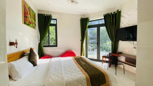 a bedroom with a bed and a desk and a television at LUCKY HOTEL LIEN PHUONG in Ho Chi Minh City