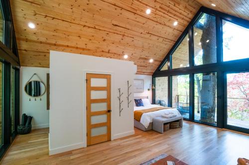 una camera con letto e ampie finestre di Private Modern Treehouse Retreat in the Forest a Cross Plains