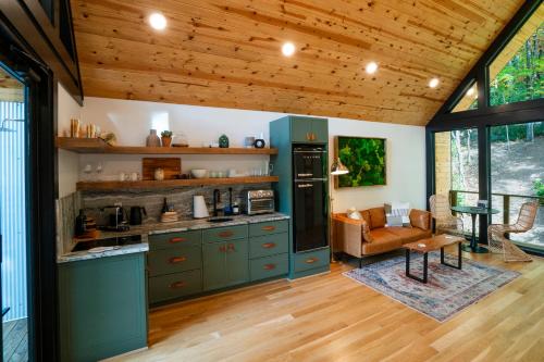 una cucina con armadi verdi e un soggiorno di Private Modern Treehouse Retreat in the Forest a Cross Plains