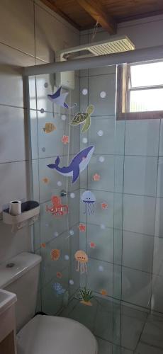 a bathroom with a shower with fish on the wall at Pousada PortoBello Praia do Rosa in Imbituba