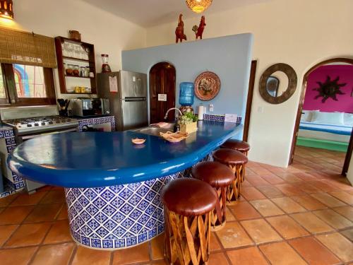 a kitchen with a blue counter top in a kitchen with stools at Casa MoJo - Whole house 7BR, heated pool, WiFi in Sayulita