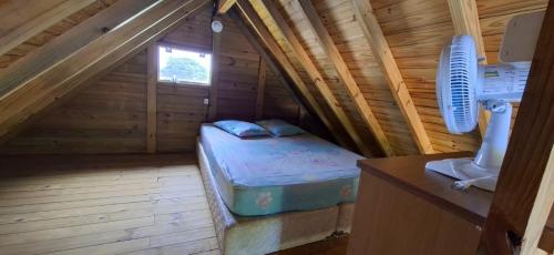 een kamer met een bed in een houten hut bij Pousada PortoBello Praia do Rosa in Imbituba