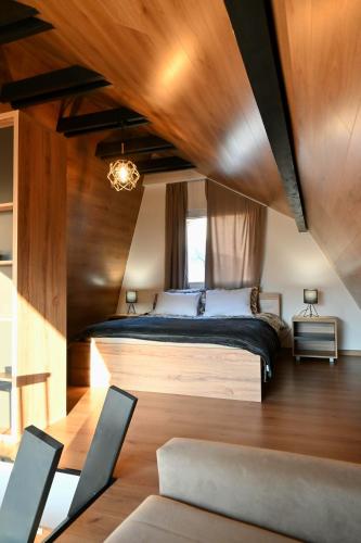 a bedroom with a large bed with a wooden ceiling at Bungalov Aurora in Pale