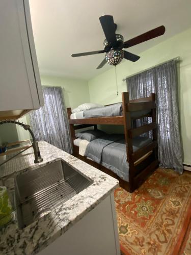 SpringfieldMust-See Okemo Mountain Resort的一间带床的卧室和一间带吊扇的厨房