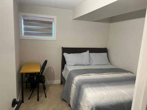 a bedroom with a bed and a desk and a window at Basement with 2 rooms in Ottawa