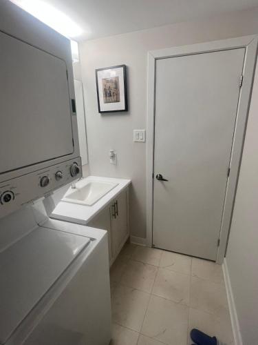 a white bathroom with a sink and a mirror at Basement with 2 rooms in Ottawa