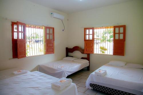 una stanza con due letti e due finestre di Casa Pamplona a Soure