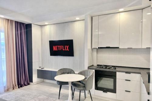 a kitchen with a table and two chairs and a stove at Nova Studio Bucharest #pool&parking in Ştefăneştii de Sus