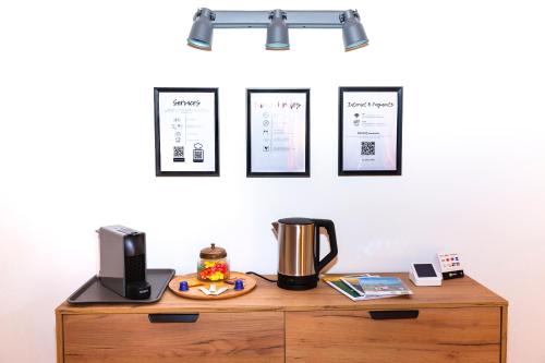 a shelf above a desk with a coffee pot and pictures on the wall at Piazza Grande House in Locarno