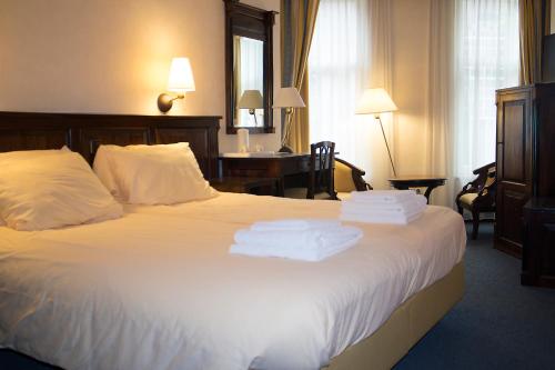 a hotel room with a bed with towels on it at Hotel Tongerlo in Roosendaal