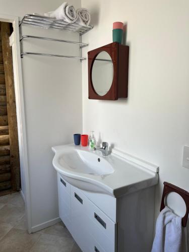 a bathroom with a sink and a mirror at Stanmore Bay Log Cabin - short walk to beach in Stanmore Bay