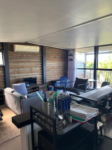 a living room with a couch and a table at Stanmore Bay Log Cabin - short walk to beach in Stanmore Bay